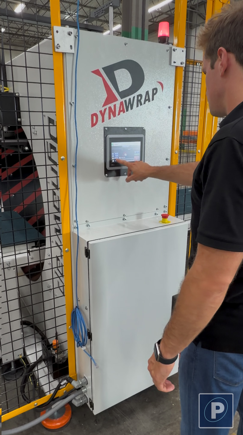 Operator programming the universal Dynawrap HMI touchscreen control panel. This exact smart interface and EHS safety protocol comes standard on the Dynawrap Pro 2200.