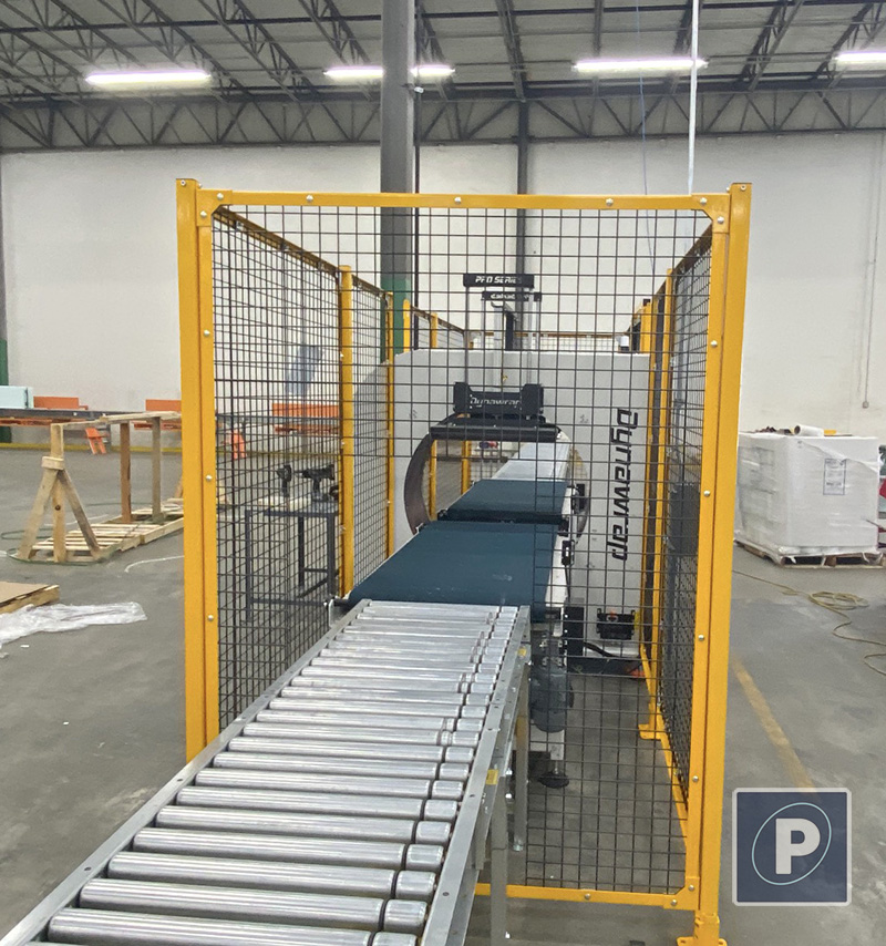 Outfeed view of the Dynawrap Pro 1100 exiting the yellow safety guarding fencing onto metal rollers